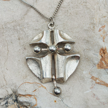 Grote vintage Finse AKT-hanger in zilver met gebogen geometrische vlakken, openingen en vier gladde bollen aan een gourmetketting.