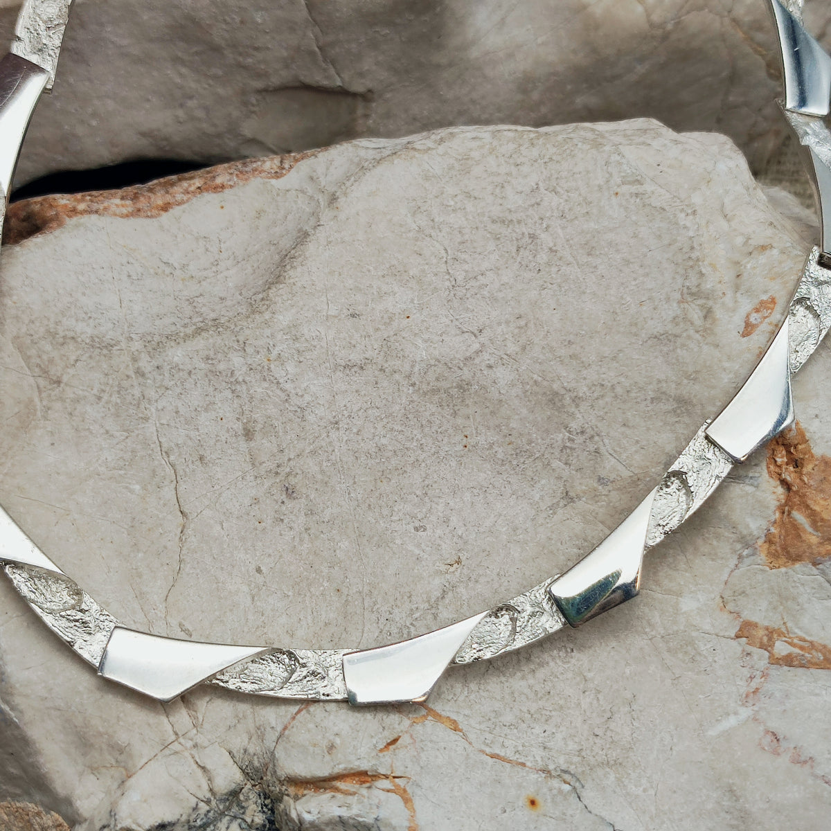 Modernistische sterling zilveren ketting van Riitta Hakala voor Tammen Koru (AKT), met gebogen schakels en afwisselend hoogglans gepolijste en ruwe oppervlakken.