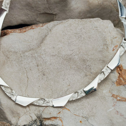 Modernistische sterling zilveren ketting van Riitta Hakala voor Tammen Koru (AKT), met gebogen schakels en afwisselend hoogglans gepolijste en ruwe oppervlakken.