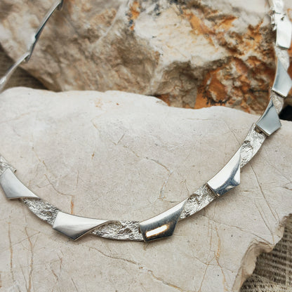 Modernistische sterling zilveren ketting van Riitta Hakala voor Tammen Koru (AKT), met gebogen schakels en afwisselend hoogglans gepolijste en ruwe oppervlakken.