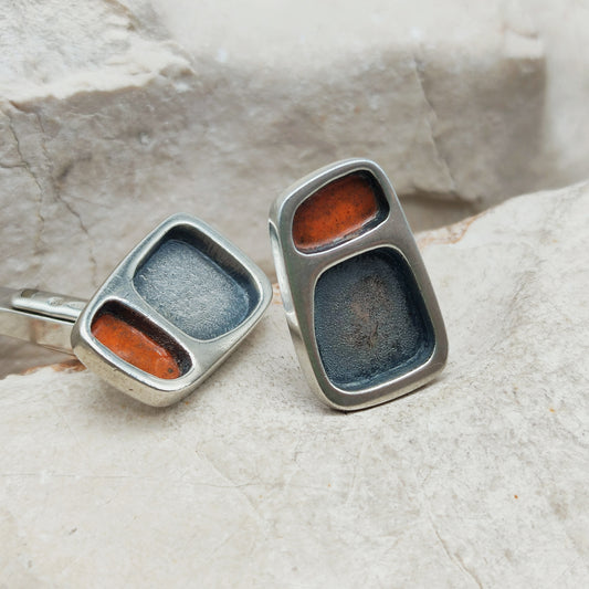 Vintage sterling zilveren manchetknopen van Mies De Wilde met asymmetrische vlakken in roodoranje email en antracietgrijs .