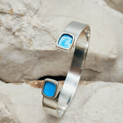 Vintage open manchetarmband van Mies De Wilde in sterling zilver met twee verhoogde turquoiseblauwe emailvlakken.