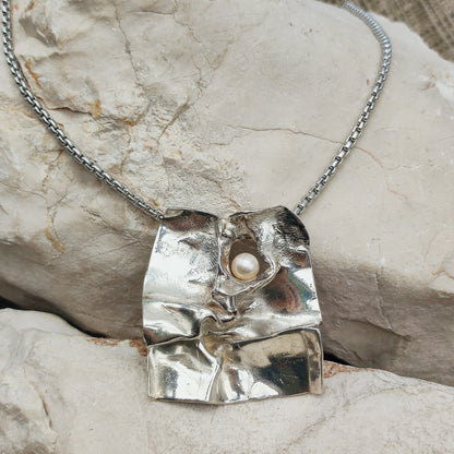 Grote brutalistische sterling zilveren hanger van Mies De Wilde met witte parel aan een stevige Binder-ketting.
