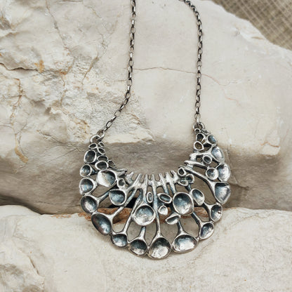 Lange vintage zilveren ketting van Hannu Ikonen voor Valo-Koru Oy met een halvemaanvormig middenstuk in rendiermosmotief.