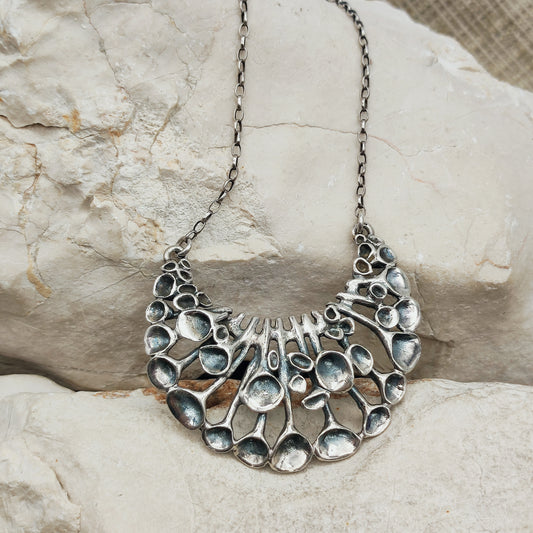 Lange vintage zilveren ketting van Hannu Ikonen voor Valo-Koru Oy met een halvemaanvormig middenstuk in rendiermosmotief.