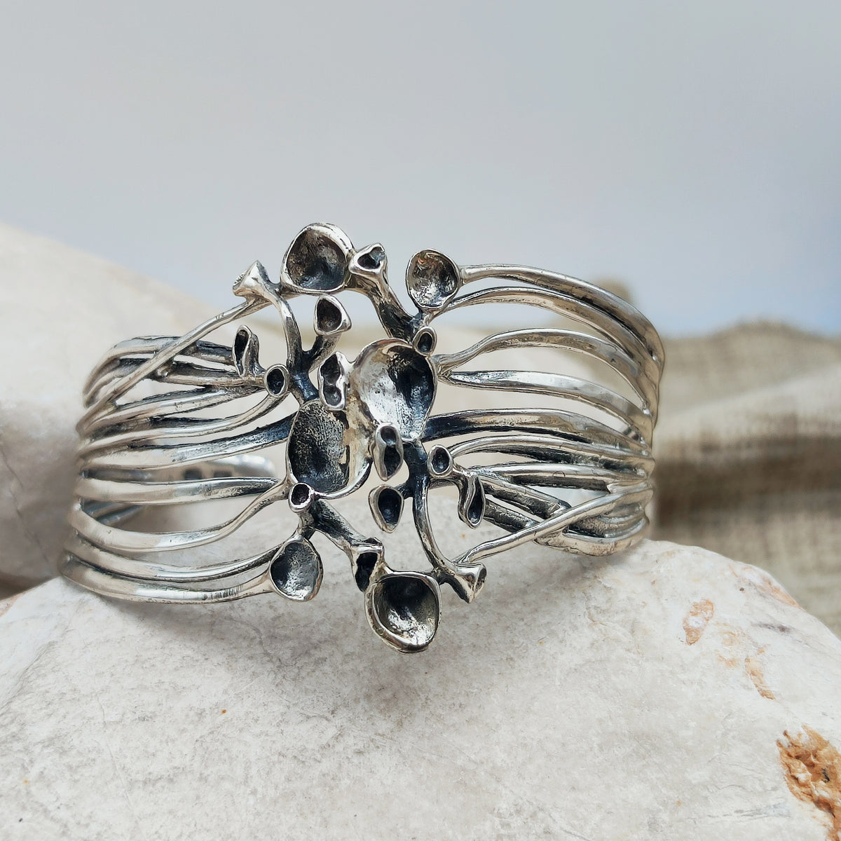 Vintage sterlingzilveren cuffarmband van Hannu Ikonen voor Valo-Koru, met opengewerkte banen en een centraal rendiermosmotief.