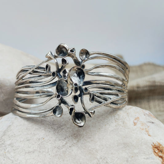 Vintage sterlingzilveren cuffarmband van Hannu Ikonen voor Valo-Koru, met opengewerkte banen en een centraal rendiermosmotief.